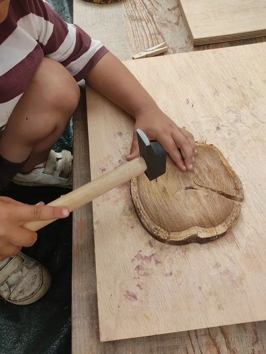 Neno traballando a madeira cun martelo